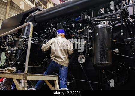 Industrial workers assembles agricultural harvester in workshop. Stock Photo