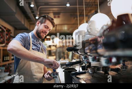 I found my lifes passion in a cup of coffee. Cropped shot of a handsome young man working in a cafe. Stock Photo