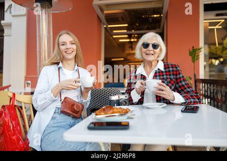 Two happy women having coffee at sidewalk cafe Stock Photo