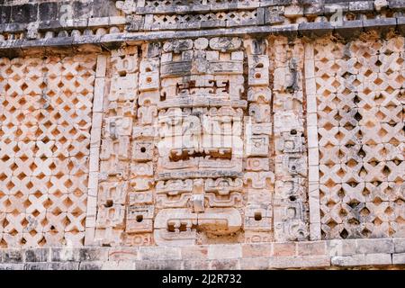 Stacks of three mayan masks on the wall of Nunnery Quadrangle (West Building) ruins in Uxmal, Yucatan, Mexico Stock Photo