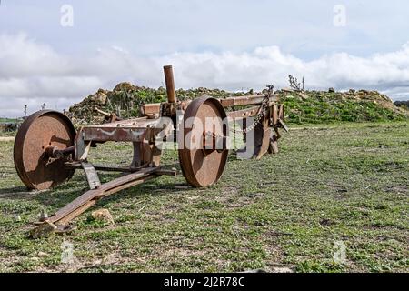 Old rusty plow on the edge of an agricultural field Stock Photo