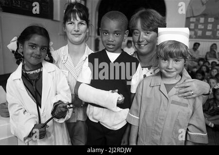 Huddersfield Royal Infirmary staff visited a Birkby school to help children overcome fears about going into hospital. But they came a day too late for one pupil of Birkby Infant and Nursery School, five-year-old Stephen Knight, who is in hospital after injuring his leg in a road accident. The other children played doctors, nurses and patients to learn about hospital work. Pictured with nursery nurse Karen Rigby (second left) and paediatric staff nurse Dawne Halsted (second right) are (from left) Neelam Iqbal, Antonio Donaldson and Bethany White. 19th May 1992. Stock Photo