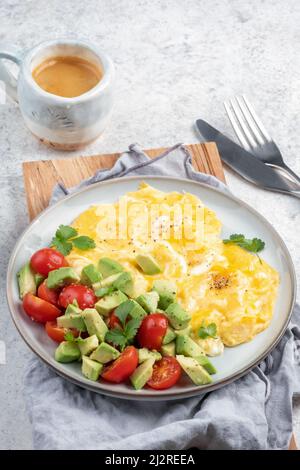 Scrambled eggs with cherry tomatoes and avocado Stock Photo