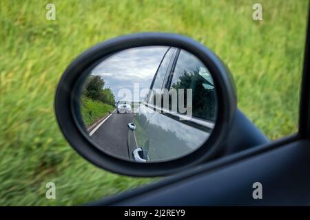 UNITED KINGDOM - MAY 28, 2019:  Motorway and traffic reflected in rear view wing mirror on car Stock Photo