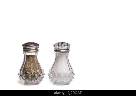 Ground salt and pepper shakers on a polished wood surface with light from a  window illuminating the table; rustic dining table with glass shakers Stock  Photo - Alamy