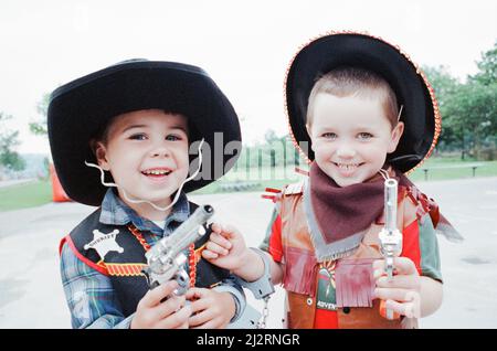 Golcar Nursery school children pictured during a Wild West fund day and barbecue, organised as a treat after they won a prize for their float at the Golcar gala, 2nd July 1992.  Howdy pardners - gun-totin' duo Jonathan Mercer and Stuart Grundy hold up the Examiner photographer. Stock Photo