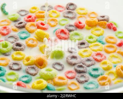 Lots of fruit grain rings in milk. Quick whole grain breakfast, healthy nutrition, vitamins, minerals, fiber, healthy lifestyle. Color image. There ar Stock Photo