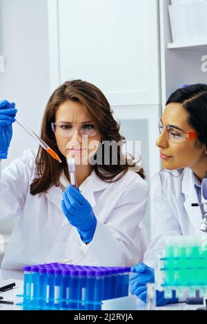 Two beautiful young female scientists working in laboratory with test tubes doing some research pharmaceutical Stock Photo