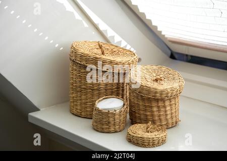 Three wicker boxes for cosmetics and personal care items in the bathroom. Stock Photo