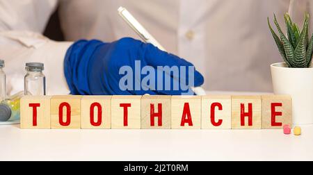 Toothache word written on wood block, concept Stock Photo