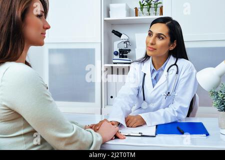 Young lady client patient visiting pleasant attentive female doctor physician at modern clinic medical center healthcare industry Stock Photo