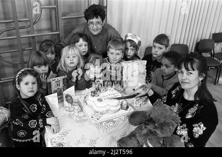 Ten years on... Mrs Lesley Holmes (right), leader of St John's playgroup in Golcar, is pictured with Mrs Catherine Nethercoats - who made the birthday cake - and the children enjoying the group's 10th birthday celebrations. Around 75 children attended the special party - which included tea and games - at St John's Junior and Infant School. The playgroup caters for children between two-and-a-half and four-and-a-half and Mrs Holmes has run it for eight years. 9th March 1992. Stock Photo