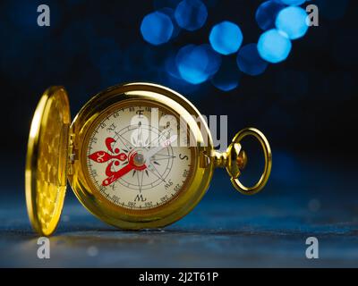 Vintage clock, golden color alarm clock on a dark blue background. Minimalism. Retro style. There are no people in the photo. Advertising business, ba Stock Photo