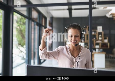Ready to provide you with the most reliable customer support. Shot of a cheerful businesswoman talking to a customer using a headset while having her Stock Photo