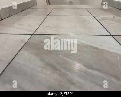 Scratched white marble floor with gray joints. Stock Photo