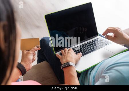 Close-up of a laptop monitor with copy space with a unrecognizable man and a woman who are shopping online with a credit card Stock Photo
