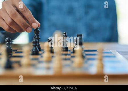 Closing in on the king. Shot of an unidentifiable man moving a chess piece. Stock Photo