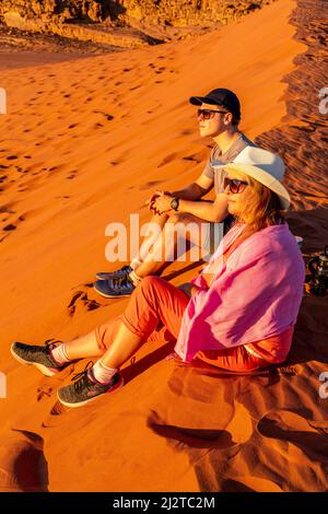 Visitors To Wadi Rum Watch The Sunset From The Red Sand Dune, Wadi Rum, Jordan, Asia. Stock Photo