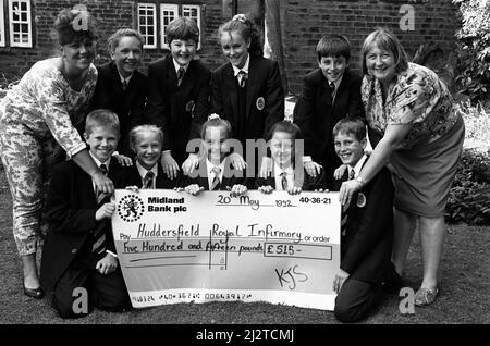 Work perfect... Year seven pupils at King James' School, Almondbury, raised more than £1,000 for charity with a sponsored spell. The money was split between the hearing dogs for the deaf charity and the children's ward at Huddersfield Royal Infirmary. Staff nurses Judith Nichols (left) and Sally Collins are pictured receiving the cheque from pupils. 20th May 1992. Stock Photo