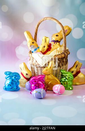 Colorful easter basket is filled with a variety of chocolate bunnies Stock Photo