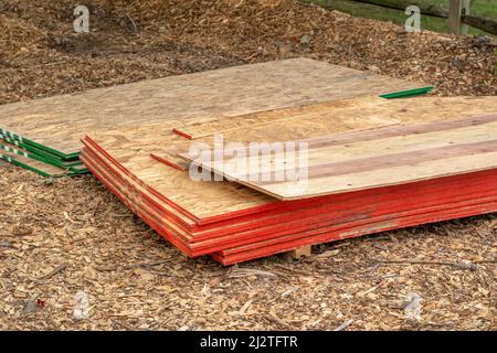 piles of sheeting are set on pallets at a job site of a new home addition Stock Photo