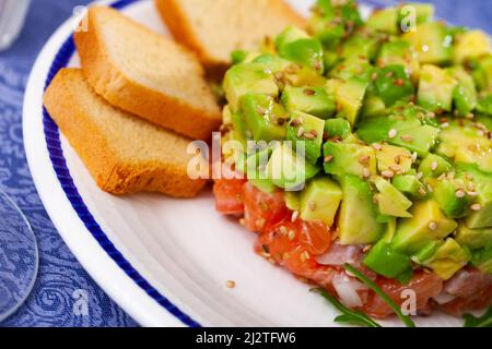 Closeup of salmon tartare with avocado served with toasts Stock Photo