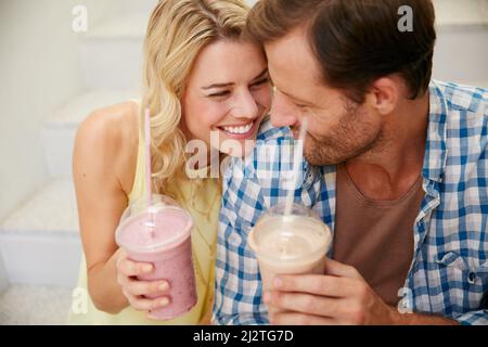 I just cant get enoughand the smoothies great too. Shot of a happy couple enjoying refreshing shakes together. Stock Photo