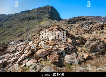 A long and steep route up to the summit of Mount Snowdon,on a sunny day in March with rocky narrow paths,loose scree and beautiful views of Snowdonia Stock Photo