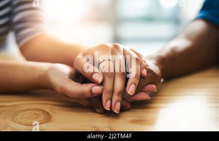 Kindness can change someones entire day. Cropped shot of an unidentifiable man and woman holding hands on a table. Stock Photo