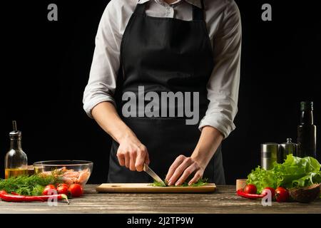 Professional chef cuts greens for salad with shrimps, the concept of seafood and healthy food. Horizontal photo, menu, recipe book Stock Photo