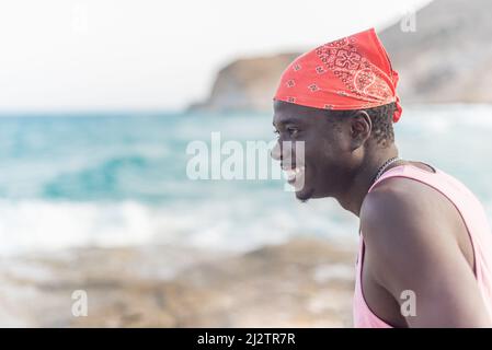 african male person happily enjoying the summer looking at ocean Stock Photo