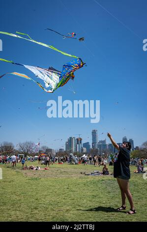 Austin, Texas, USA. 3 April, 2022. Cristal, 26, of Austin flys her dragon kite. The 93rd ABC Kite Festival returned to Zilker Park Sunday. Thousands of visitors flew colourful kites across the 350 acre park.  Credit: Sidney Bruere/Alamy Live News Stock Photo