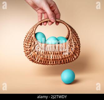 Hand with blue dyed Easter eggs in basket. Woman using natural farm food for preparation for spring religious holiday. High quality photo Stock Photo