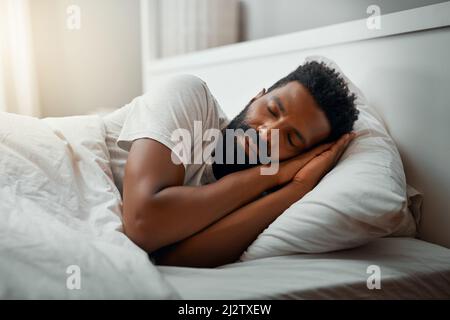 Sleeping in over the weekend. Cropped shot of a handsome young man sleeping in bed at home. Stock Photo