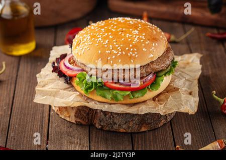 Fresh appetizing burger on wooden background Stock Photo