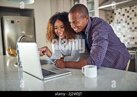 Have you seen this. Cropped shot of an affectionate young couple using a laptop in their kitchen at home. Stock Photo