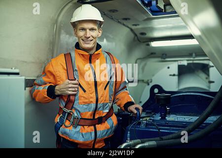Trust me, Im an engineer. Portrait of a young engineer working with complicated machinery while wearing safety gear. Stock Photo