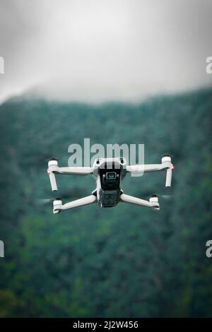 DJI Drone flying in a forest Stock Photo
