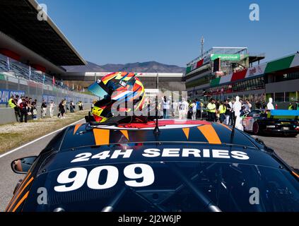 Racing helmet motor sport equipment on top of gt car on starting grid. Mugello, Italy, march 27 2022. 24 Hours series Stock Photo