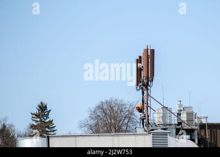Mobile phone and internet cell tower over against sky. 5G wireless radiation antennas. Stock Photo