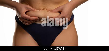 woman squeezing her belly fat on white background Stock Photo