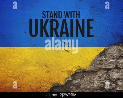 Stand with Ukraine message on worn old brick wall painted in colors of Ukrainian flag, copy space included Stock Photo