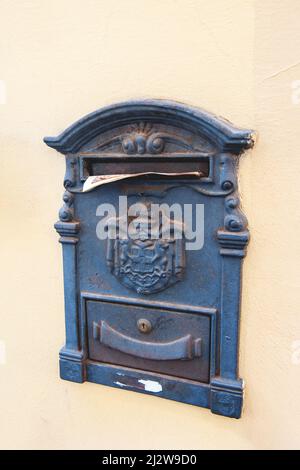 old metal mailbox on a smooth wall. copy of the space. mailbox for paper correspondence Stock Photo