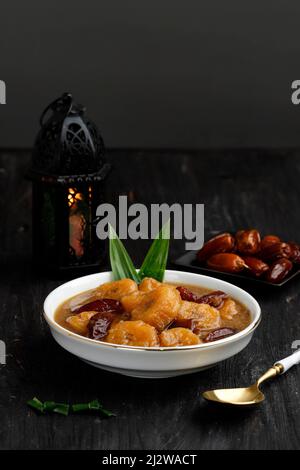 Kolak Kurma Pisang, Traditional Indonesian Compote made from Date Fruit and Sliced Banana. Popular Food Beverages for Iftar. Kolak Made from Coconut M Stock Photo