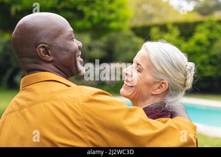 Cheerful multiracial senior couple spending leisure time together in backyard Stock Photo