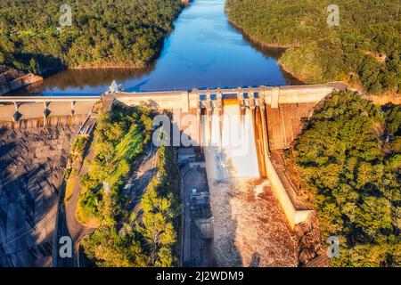 Spilling over the Warragamba dam leaking water in Blue Mountains of Australia during floods - aerial view. Stock Photo