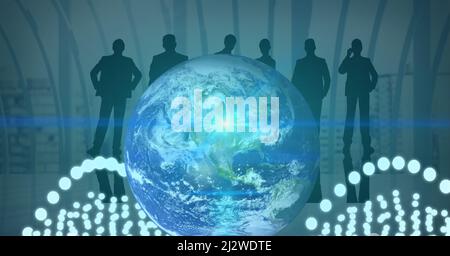 Blue spot of light and white glowing spots over globe against silhouettes of businesspeople Stock Photo