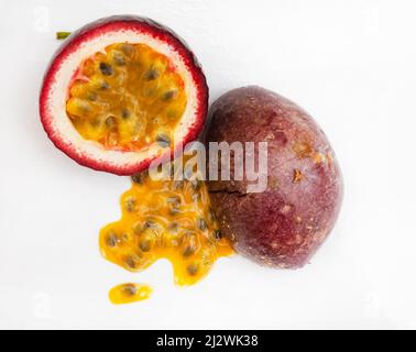 Granadilla or passion fruit, cut open with pulp on white background Stock Photo