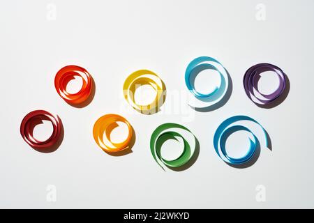 Rainbow colored paper circles on white background. Multicolor spirals pride Stock Photo