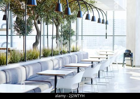 Background image of empty food court interior in shopping mall with tables and chairs in neutral grey tones lit by sunlight, copy space Stock Photo